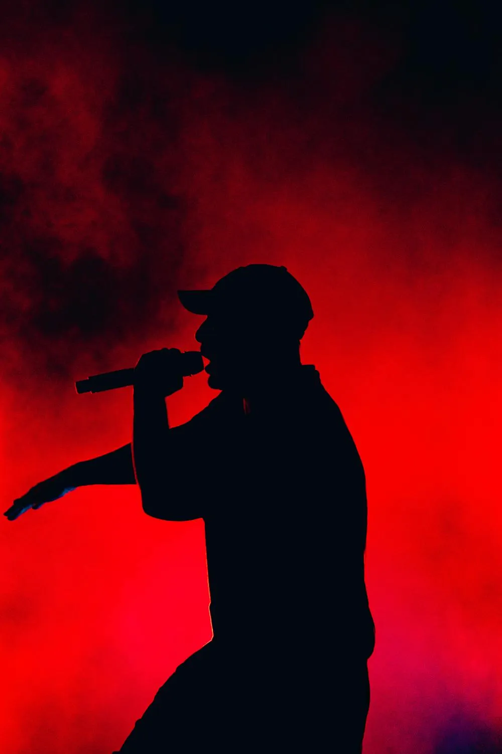 Chanteur sur scène avec fumigènes en fond